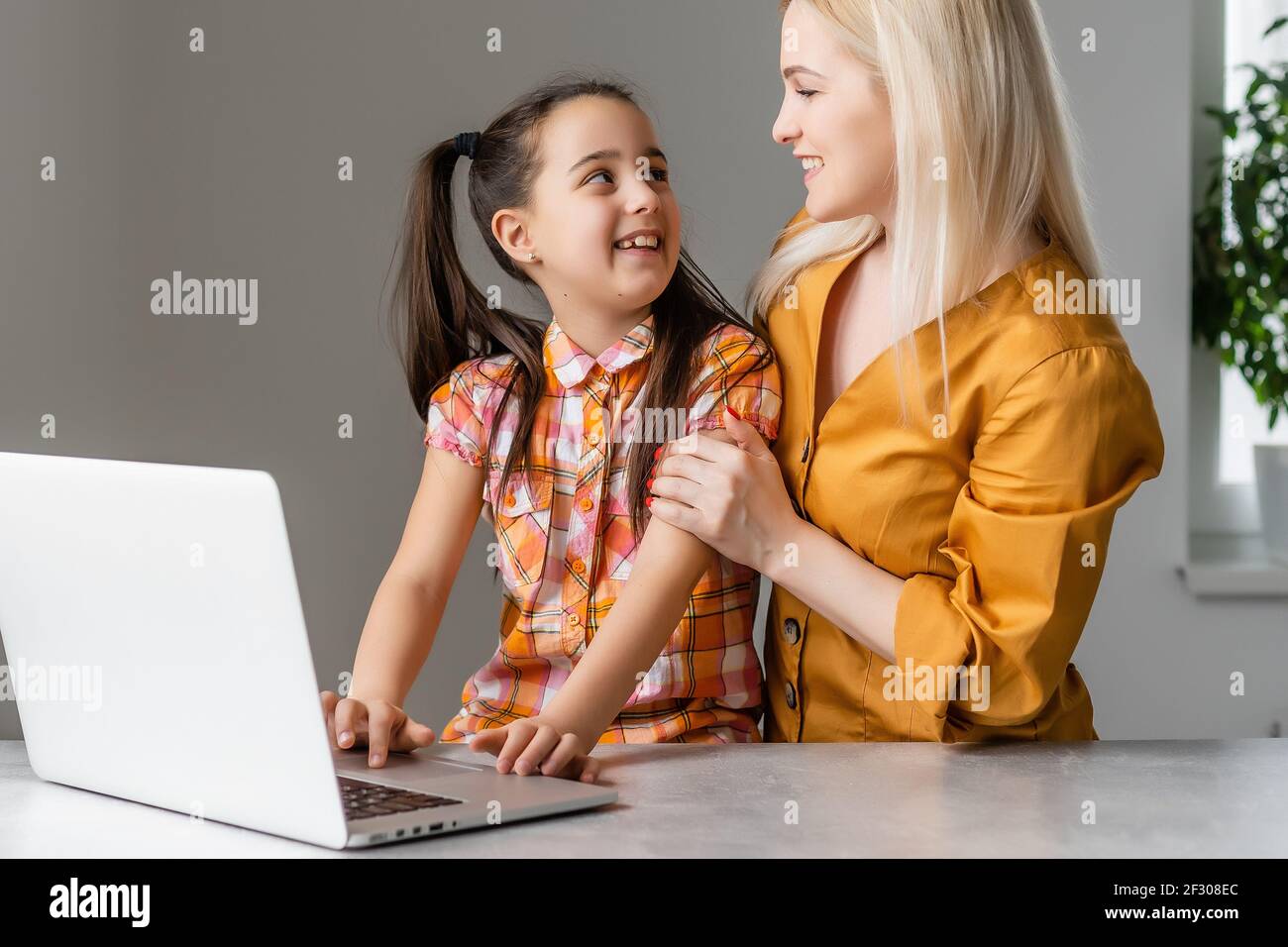 Helpful mother explaining to daughter about using a laptop Stock Photo