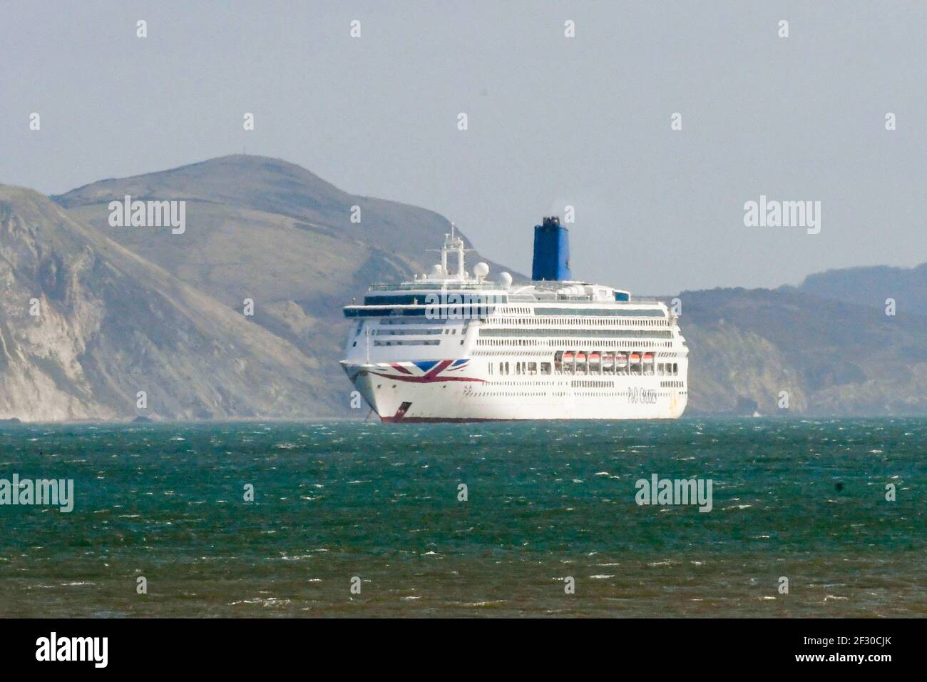 Weymouth, Dorset, UK.  14th March 2021.  UK Weather.  The empty P&O cruise ship Aurora anchored in the bay at Weymouth in Dorset during the Covid-19 lockdown.  Picture Credit: Graham Hunt/Alamy Live News Stock Photo