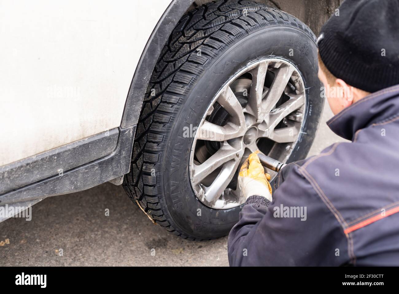 Car mechanic removing wheel nuts to check brakes Stock Photo Alamy