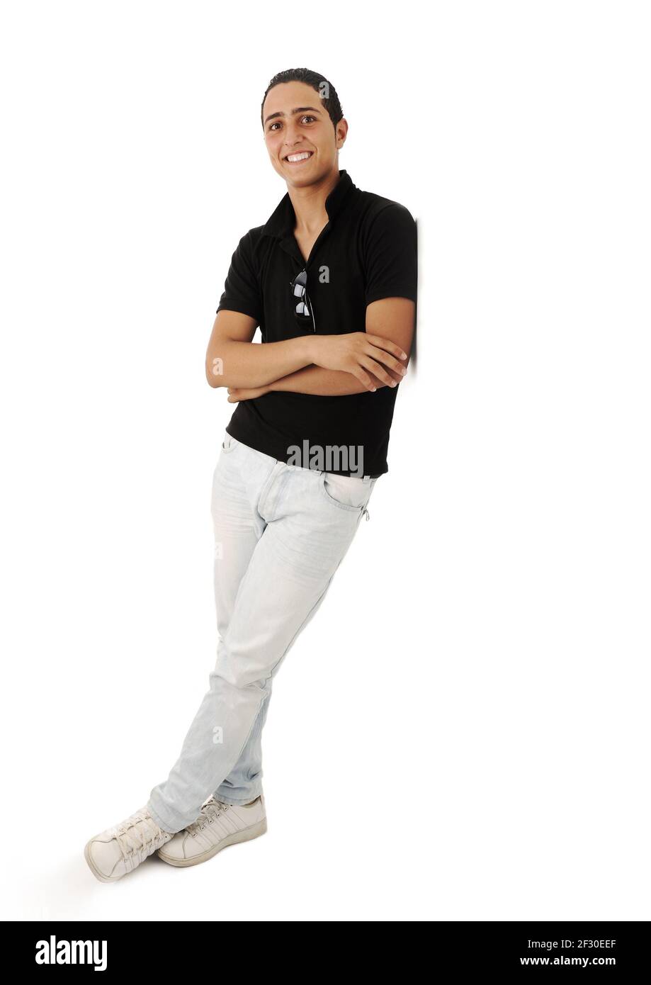 Arabic guy standing against the wall smiling, isolated Stock Photo