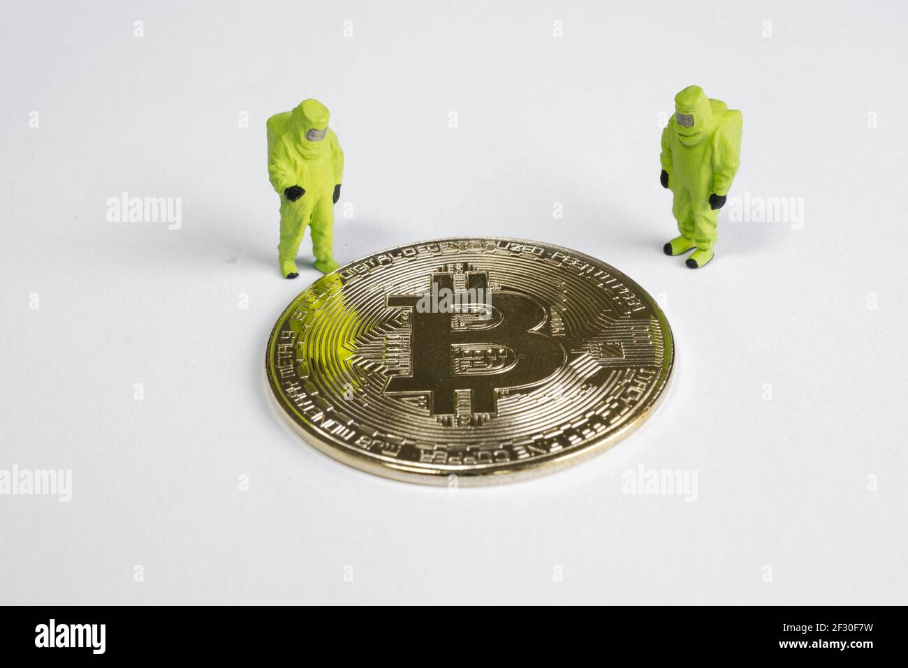 macro figures lookking on bitcoin. virtual cryptocurrency mining concept Stock Photo