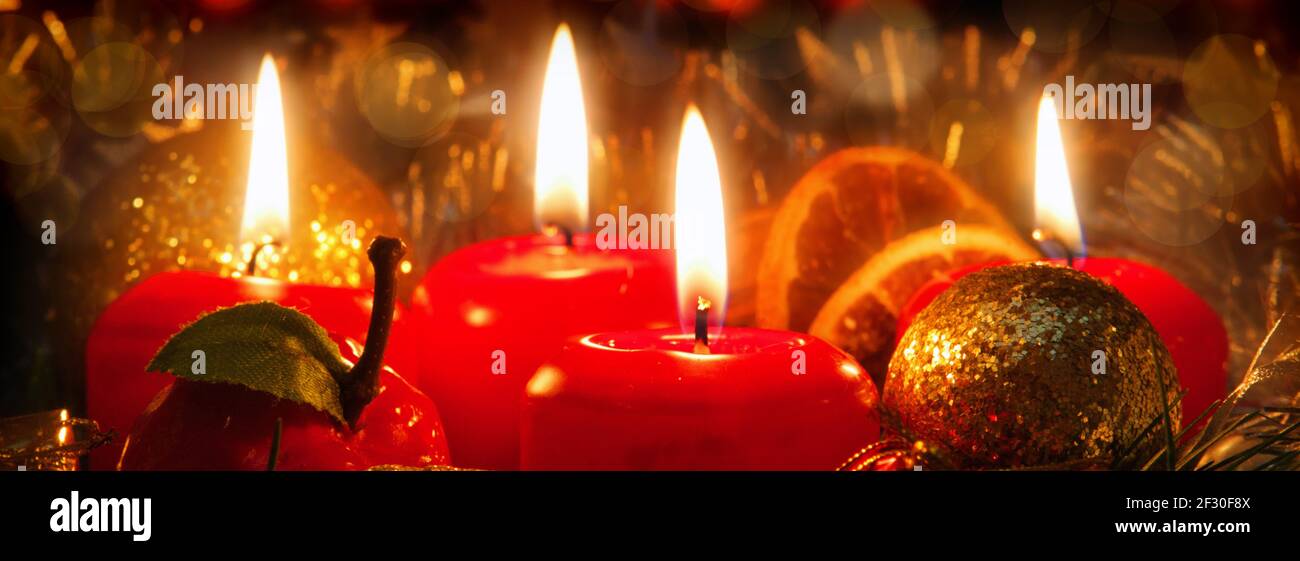 Four red candles with christmas ball in atmospheric light. Stock Photo