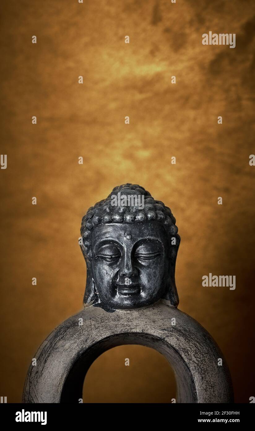 Buddha statue on orange red textured background. Spirituality, meditation and tranquility concept. Stock Photo