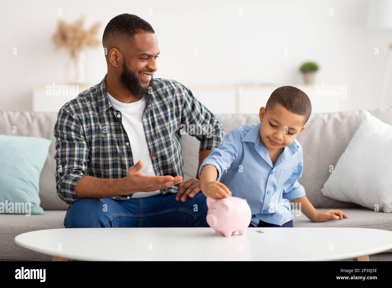 Father and son putting coin piggy bank hi-res stock photography and ...