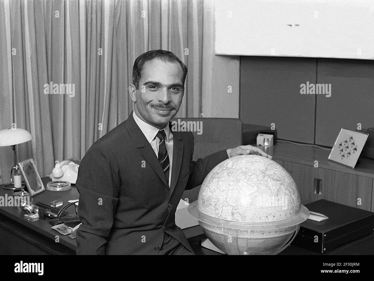 KING HUSSEIN of Jordan at office with a glob Stock Photo
