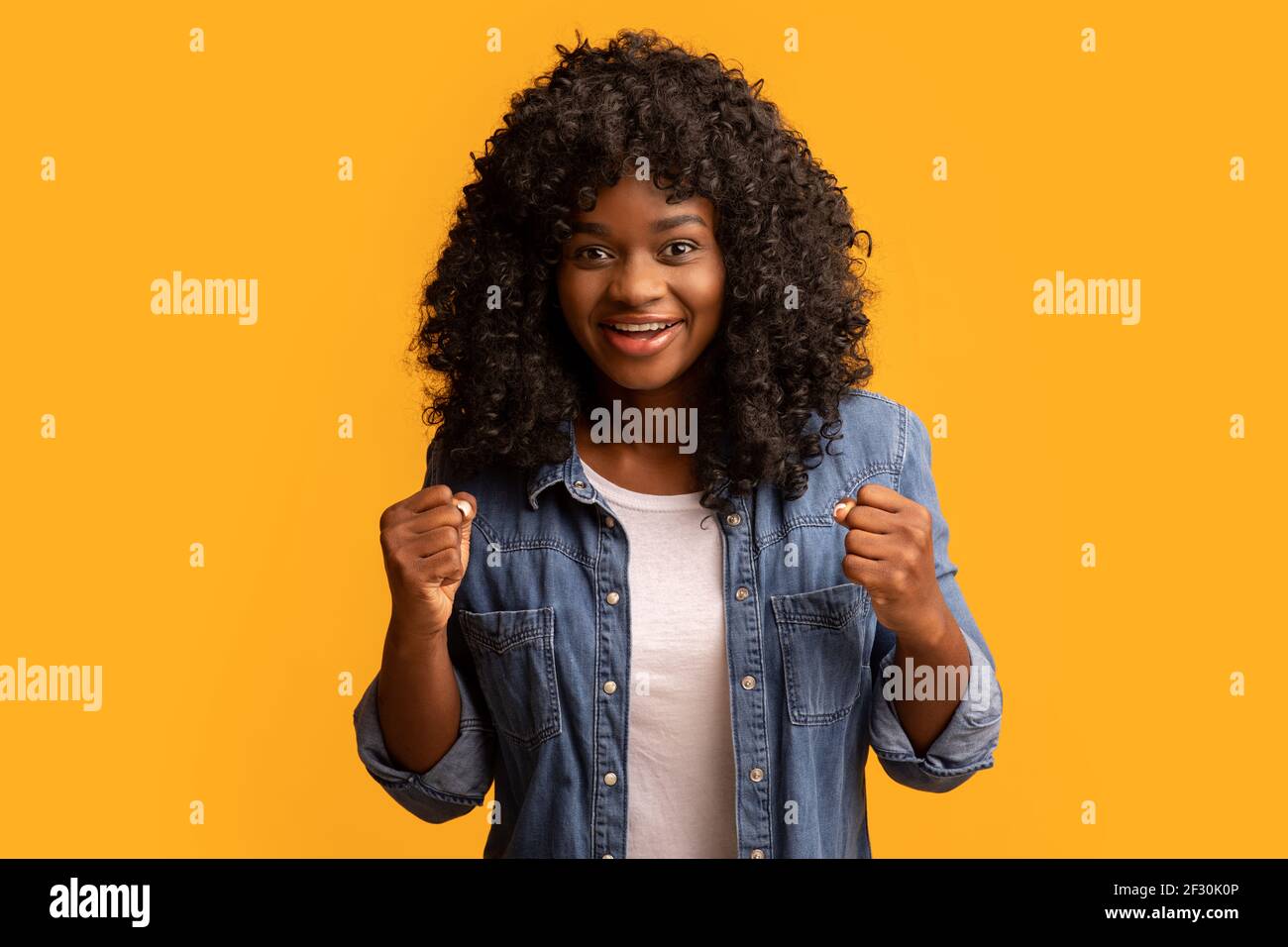 Excited black lady raising fists up and smiling Stock Photo