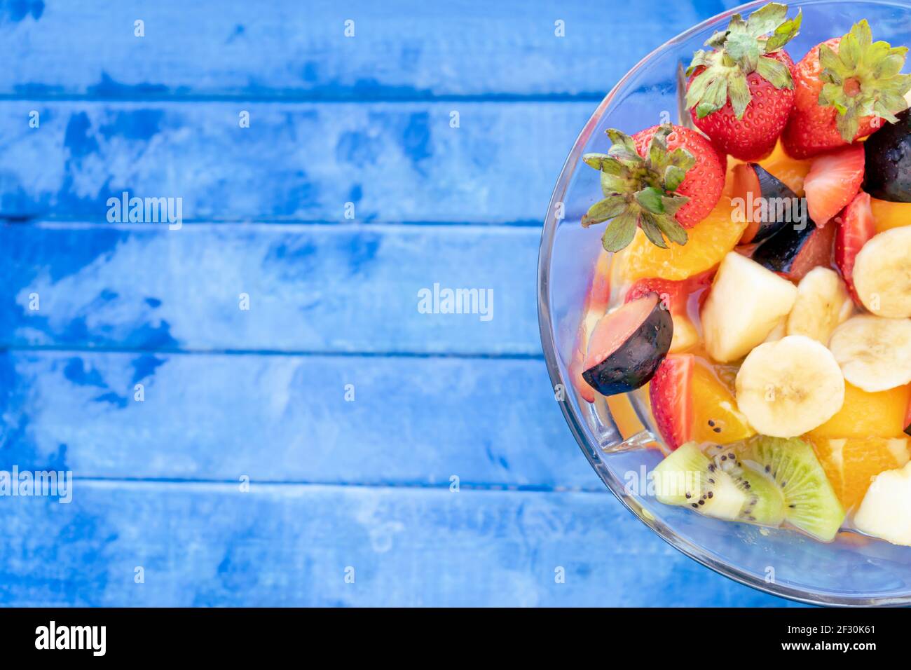 Natural and healthy fruit salad with orange set in a transparent glass
