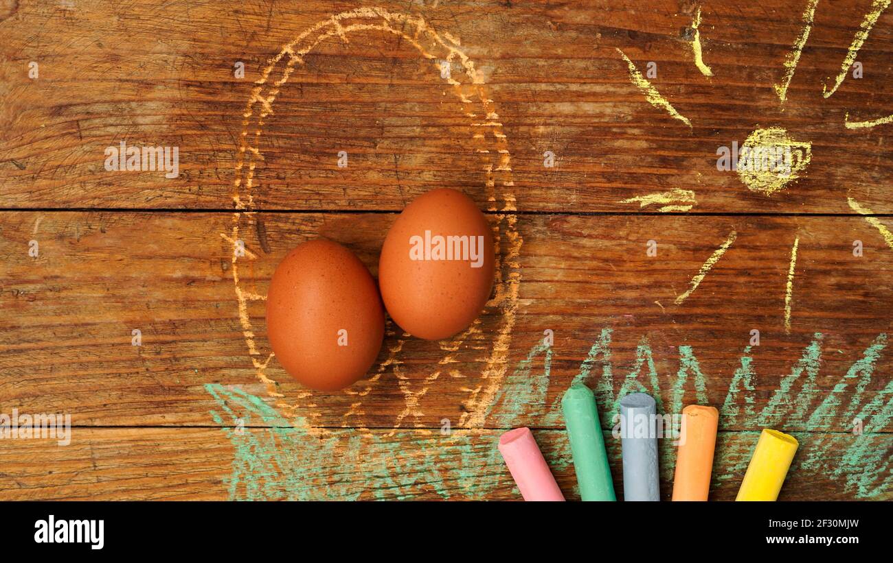 Easter eggs in a basket. Drawing with colored chalk on a wooden background Stock Photo