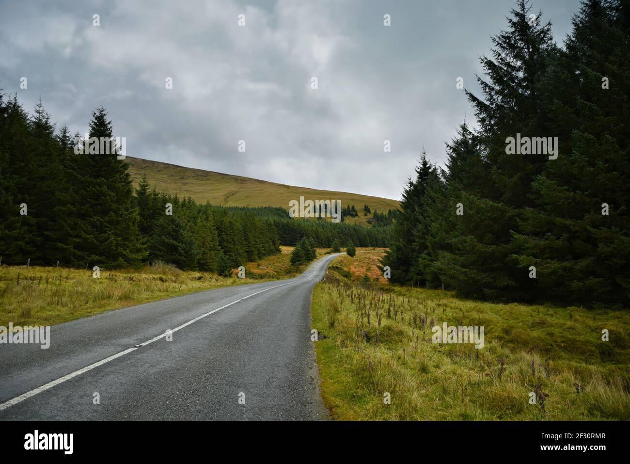 Autumn landscape with an isolated rural highway in the countryside of County Wicklow in Leinster, Ireland. Stock Photo