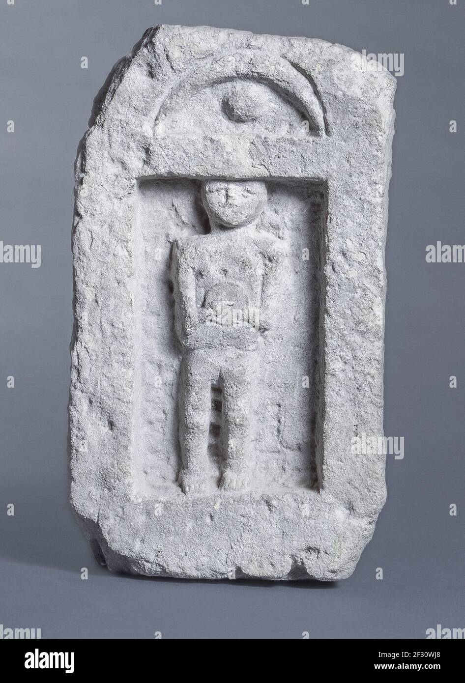 Itsly Sardinia Province of Cagliari - Sant'Antioco - Archaelogical civic museum -Punic stele from the tophet of Sant'Antioco - female figure with chest disc inside aedicule with astral symbols Stock Photo
