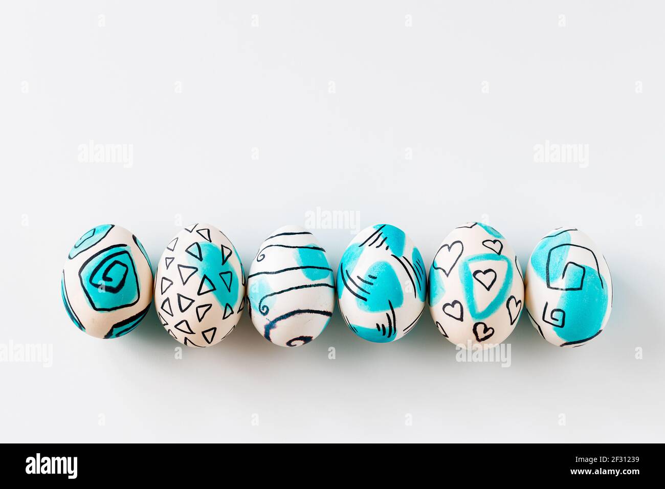 Creative trendy painted easter eggs on white background. Easter ideas. Stock Photo