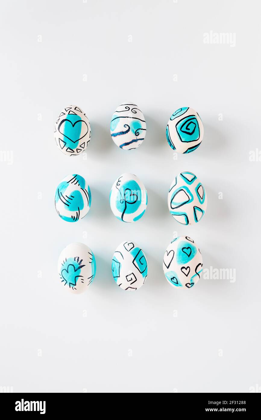 Creative trendy painted easter eggs on white background. Easter ideas. Stock Photo