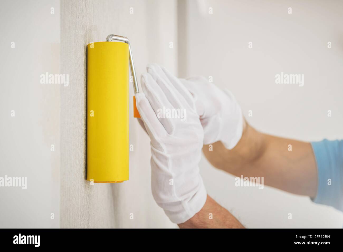 Vinyl Wallpapers Wall Application Using Squeegee Seam Roller. Apartment