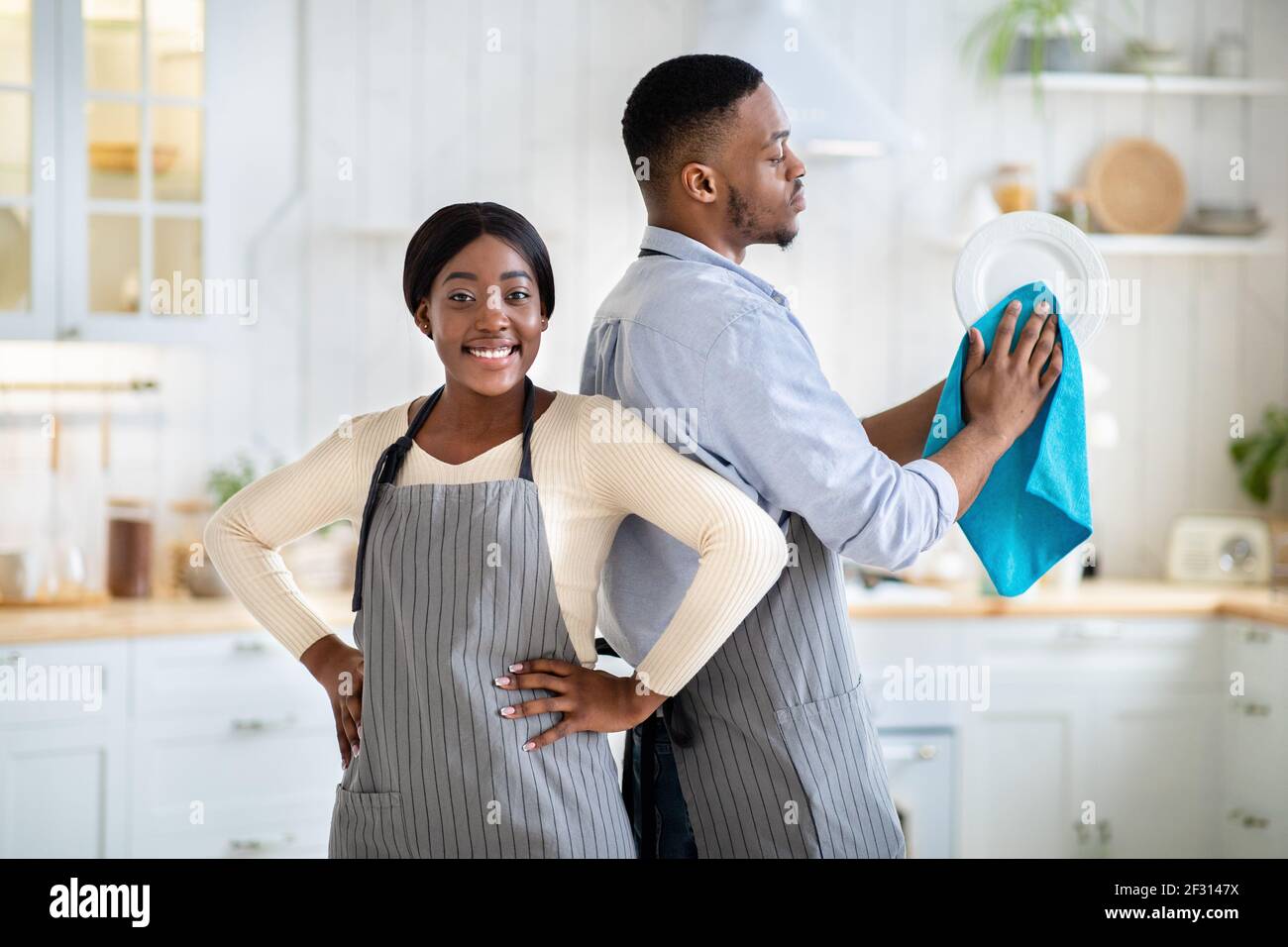 1960s 1950s SMILING MAN HUSBAND IN APRON WASHING AND DRYING DISHES IN  KITCHEN - s10163c DEB001 HARS OLD FASHION 1 TOWEL DISH ASSISTANT LIFESTYLE  STUDIO SHOT HOME LIFE COPY SPACE HALF-LENGTH DRY