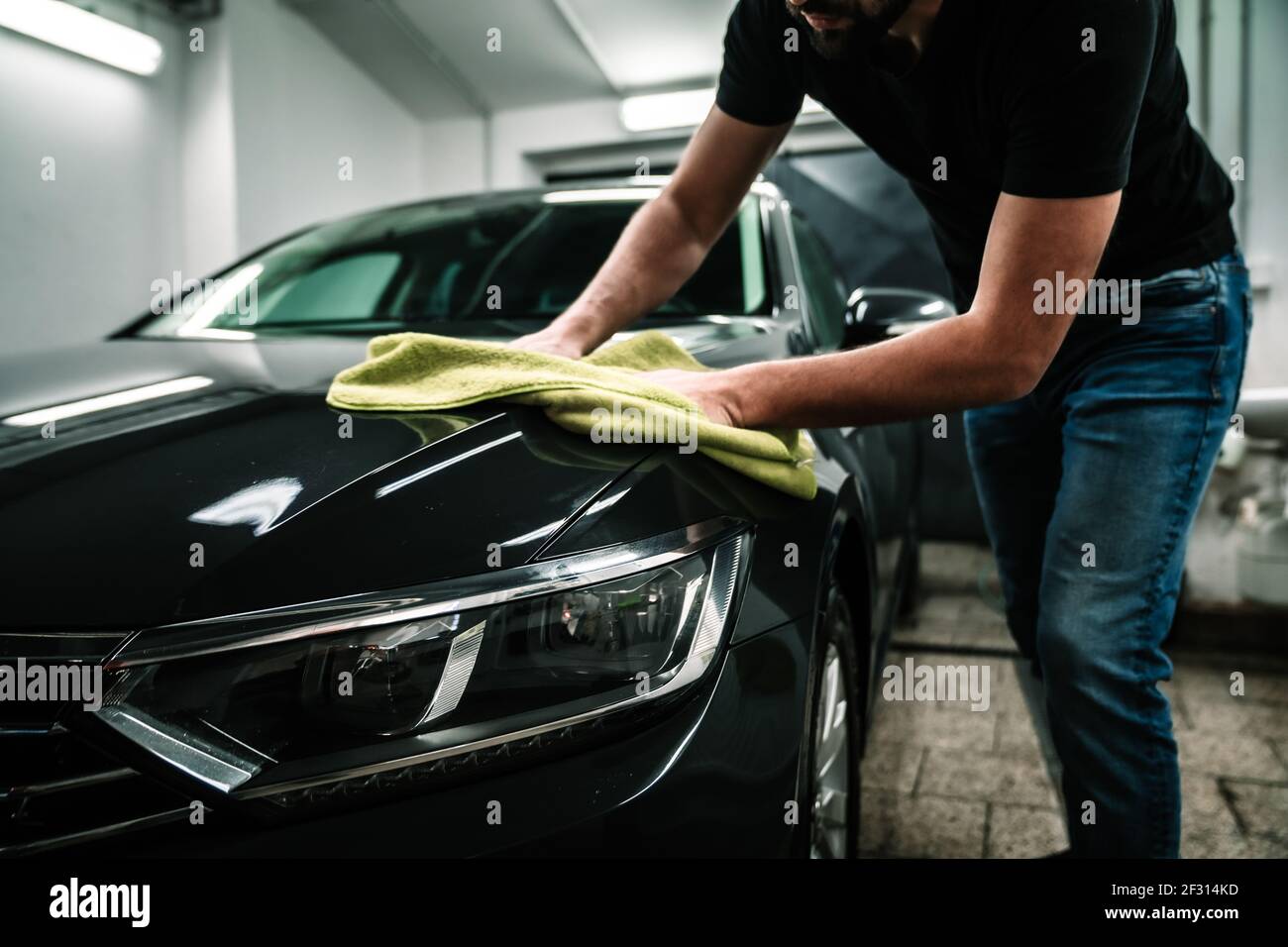 man cleans the car body with a towel. auto care Stock Photo