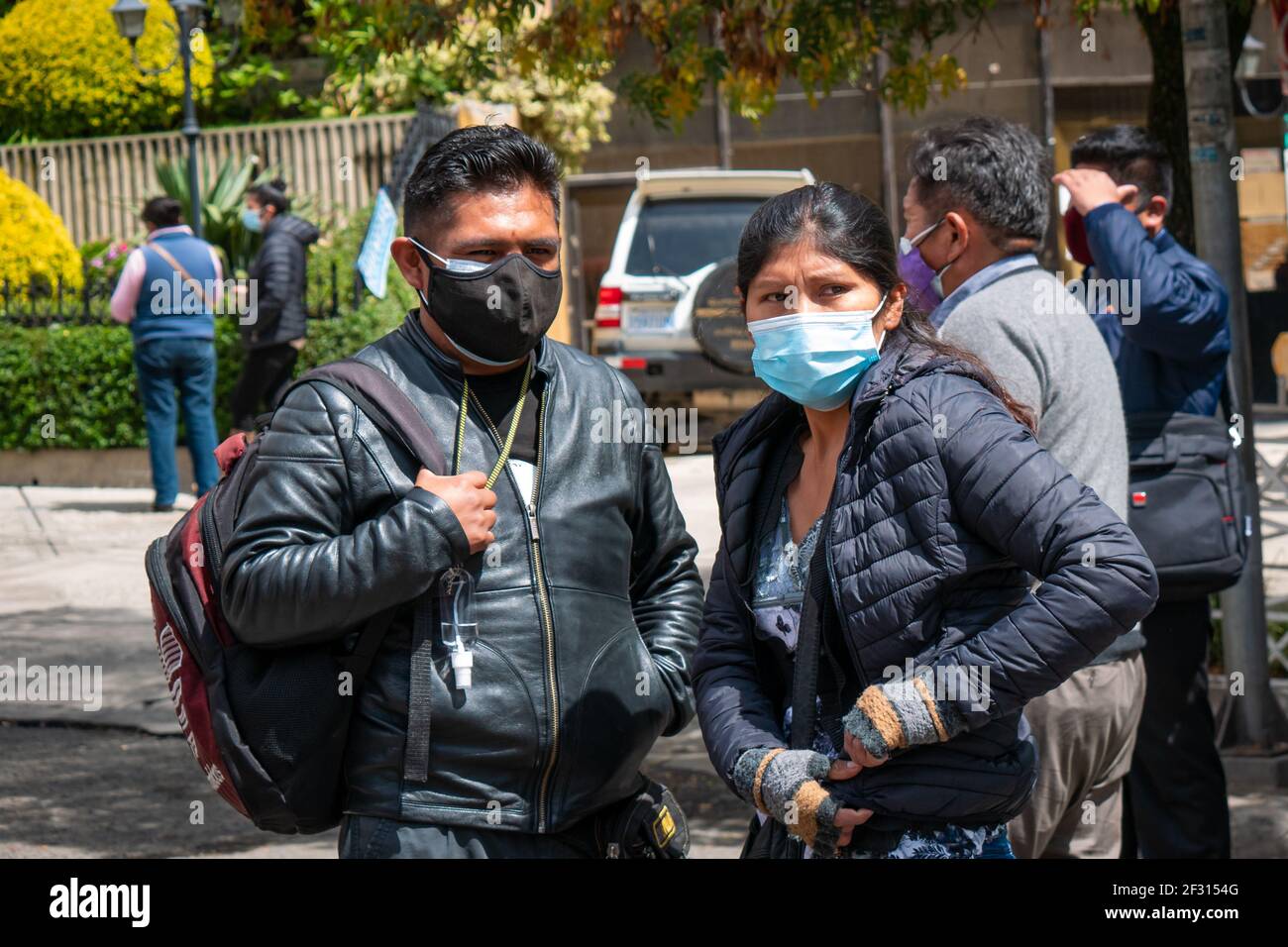 La Paz, Bolivia - February 11 2021: Bolivian Indigenous Woman and Man Waiting for Public Transportation on the Street Stock Photo