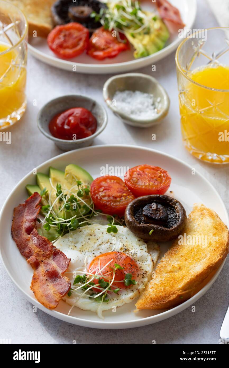 Breakfast with fried egg, tomatoes, mushroom, bacon and avocado Stock Photo