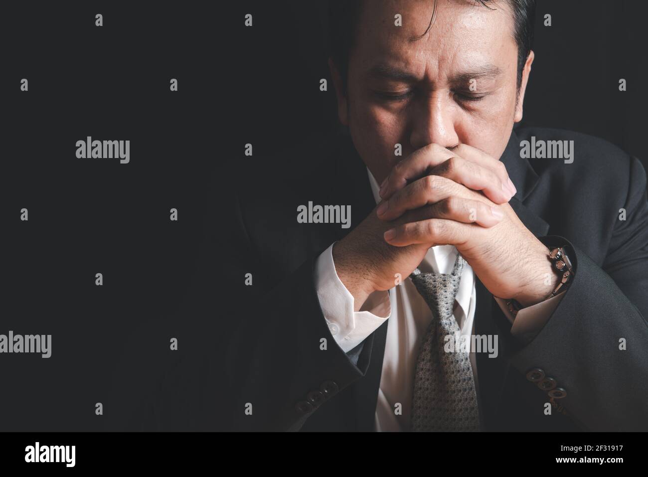 Stressed businessmen put their hands together while reviewing stories