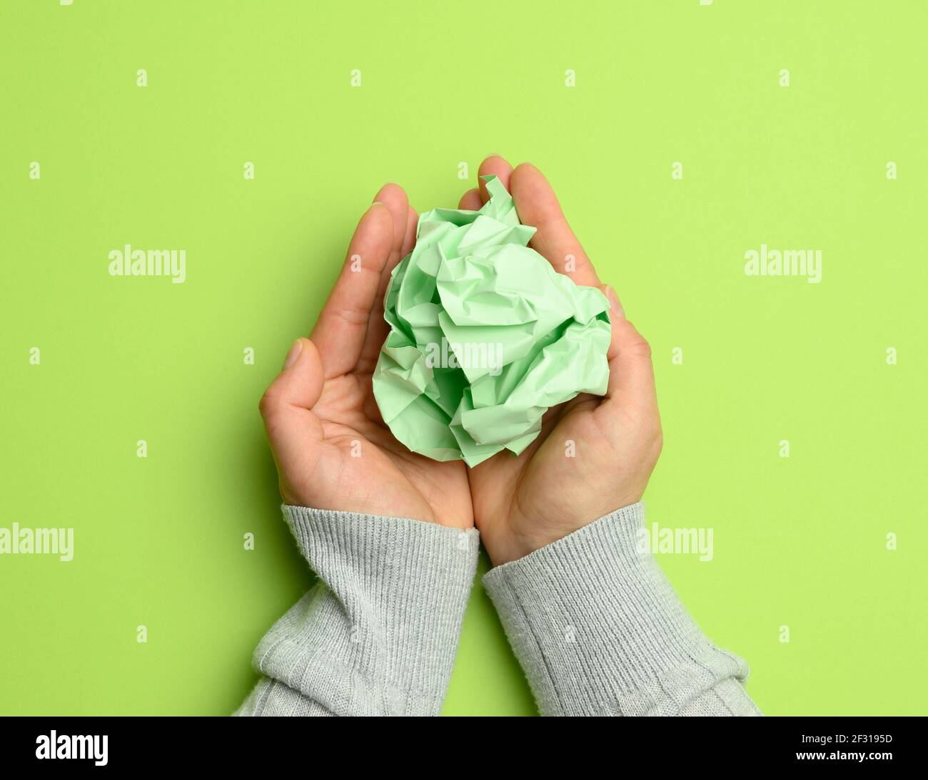 Mint green sheet of paper in a female hand on a green background Stock ...