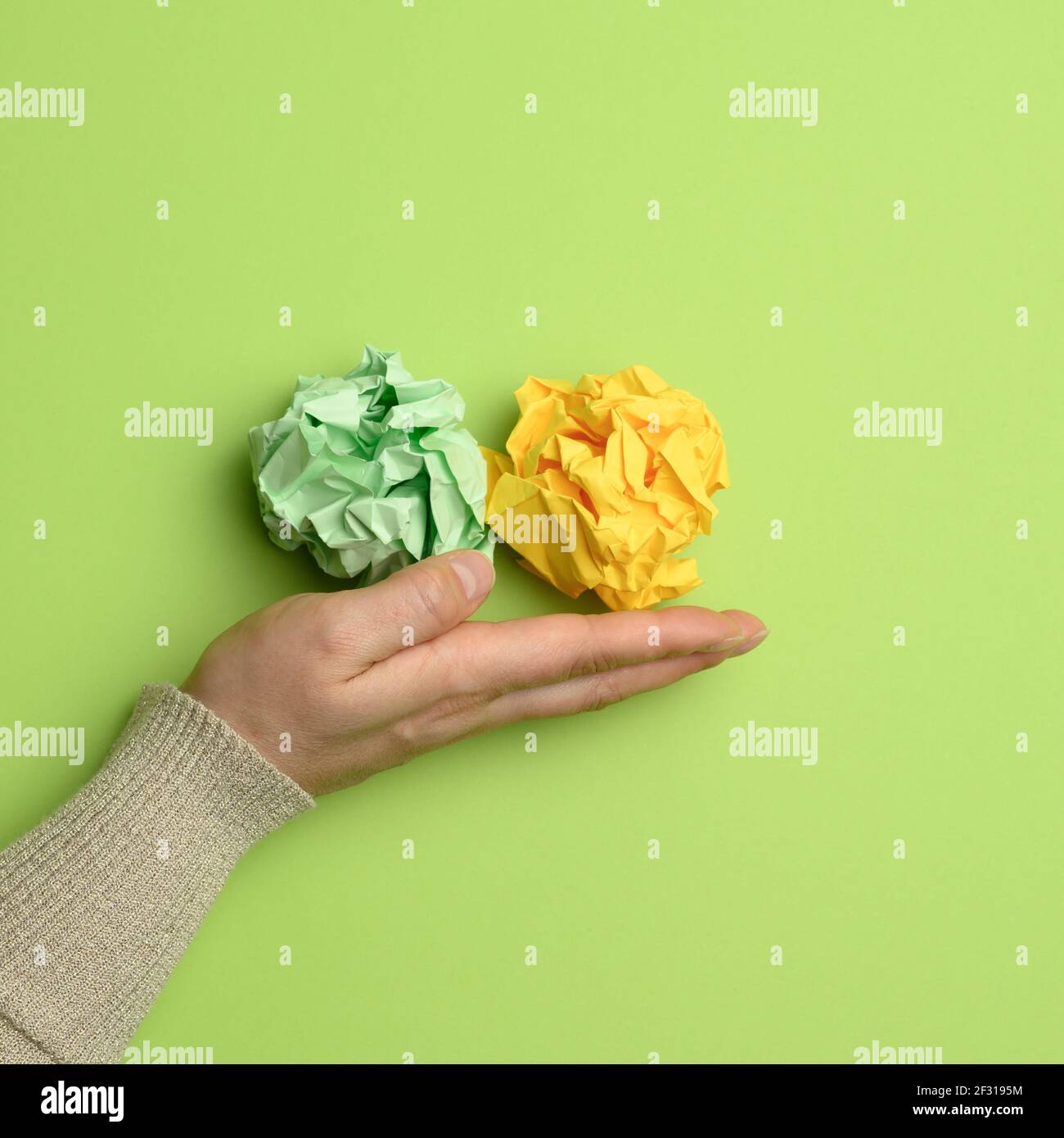 Green and yellow crumpled ball of paper in a female hand Stock Photo ...