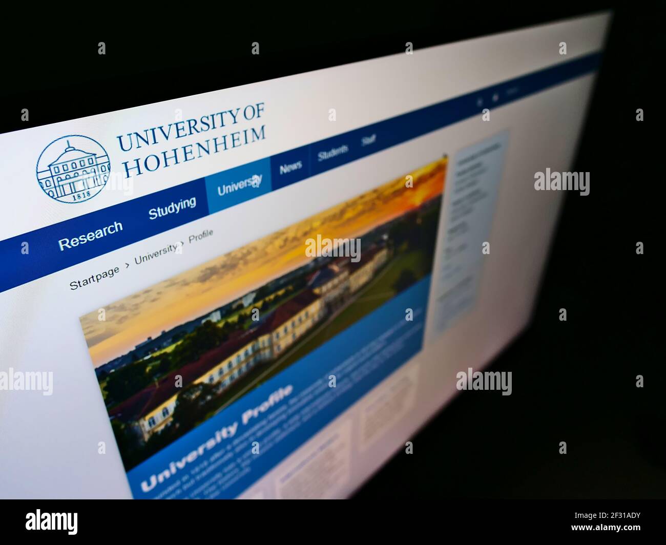 High angle view of website with logo of German education instituion University of Hohenheim in Stuttgart on monitor. Focus on top-left of screen. Stock Photo