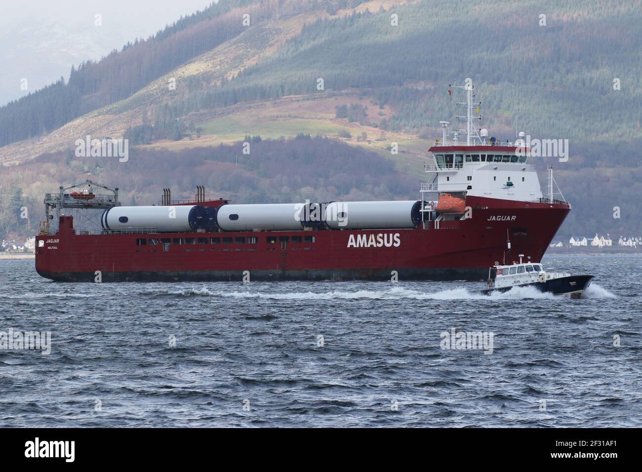 Jaguar, a general cargo vessel operated by Amasus Shipping, with the Clydeport pilot boat Mount Stuart, passing Gourock on the Firth of Clyde. Stock Photo