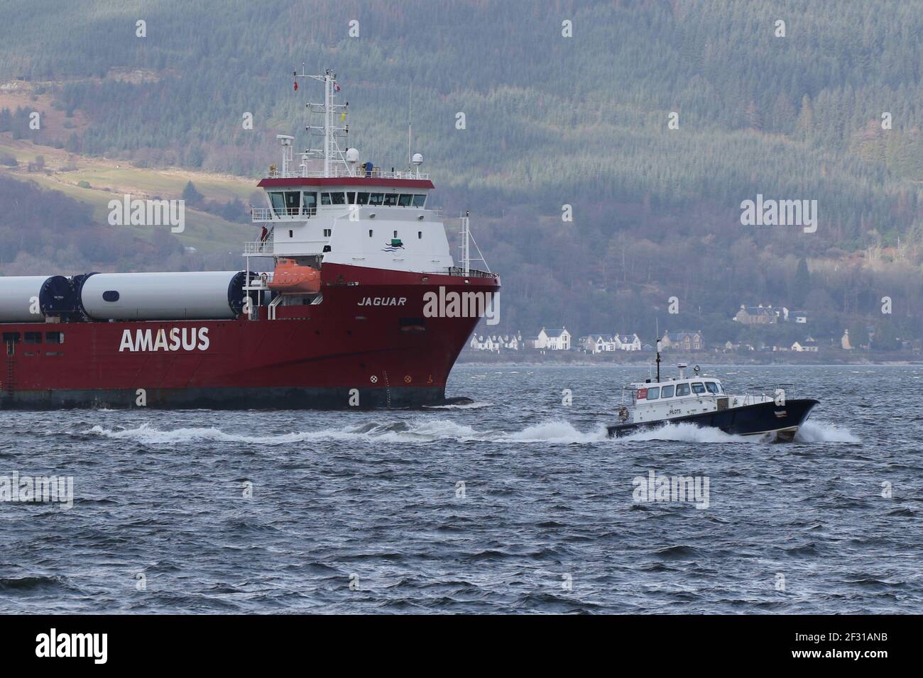 Jaguar, a general cargo vessel operated by Amasus Shipping, with the Clydeport pilot boat Mount Stuart, passing Gourock on the Firth of Clyde. Stock Photo