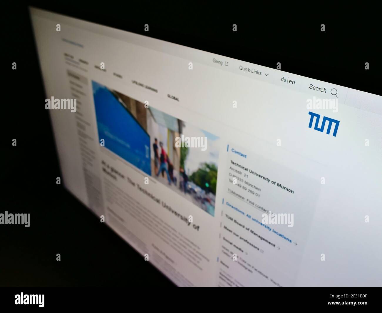 High angle view of web page with logo of German education institution Technical University of Munich on monitor. Focus on top-left of screen. Stock Photo