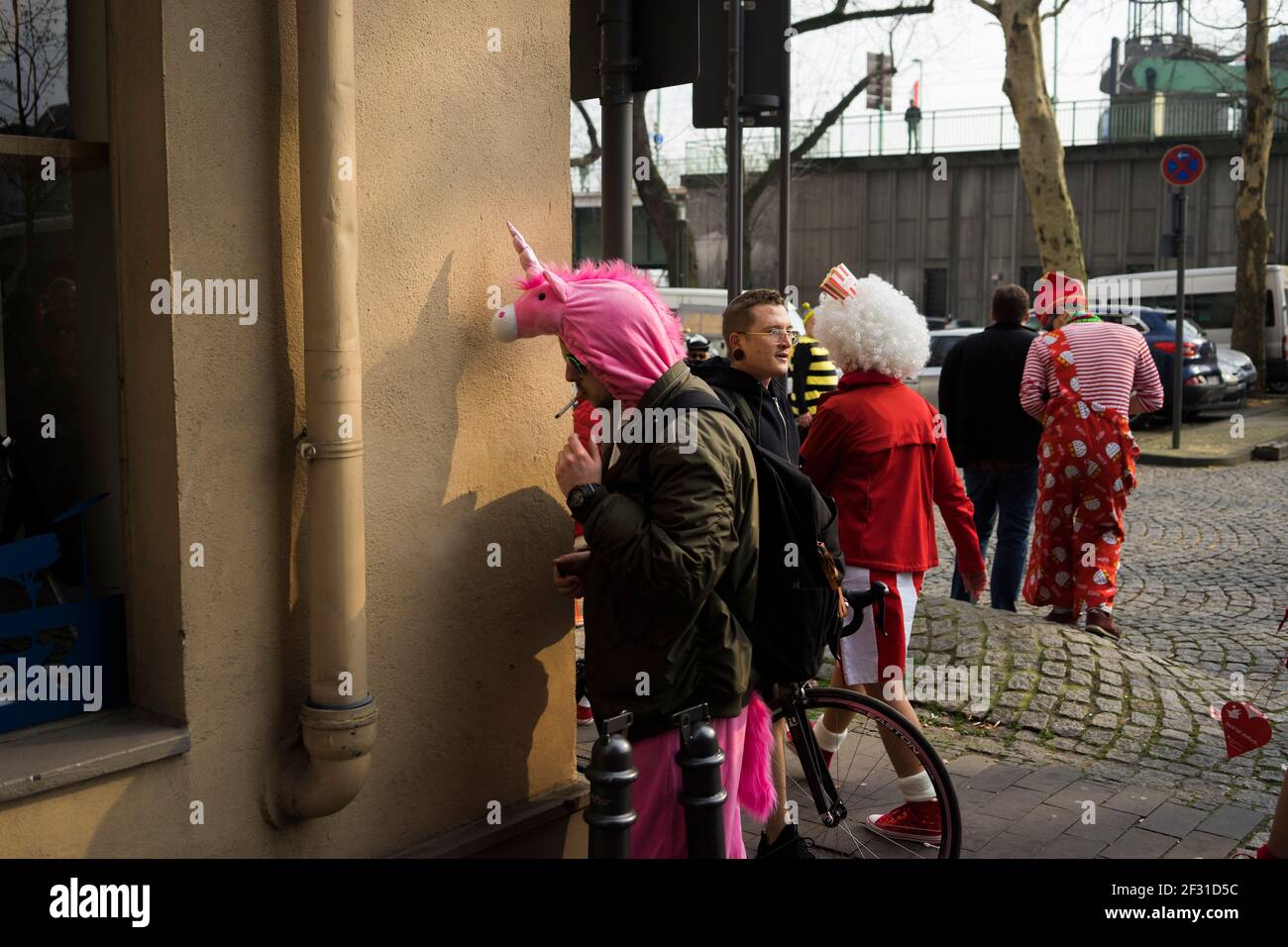 A man lights his cigarette during Carnival, Cologne Stock Photo