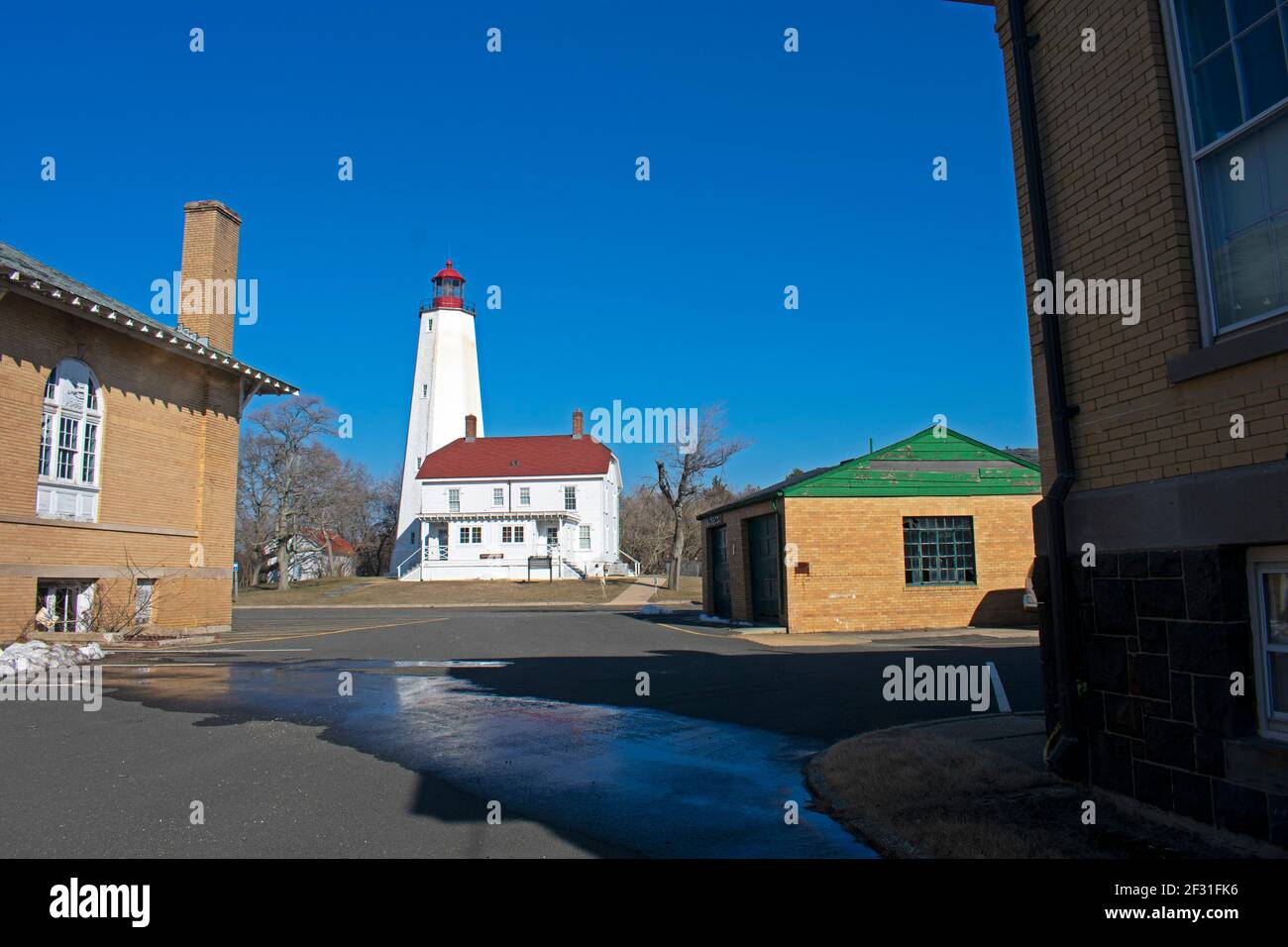 Lighthouse in Sandy Hook, New Jersey, in a late winter afternoon, with snow still on the ground and the light turned off -40 Stock Photo