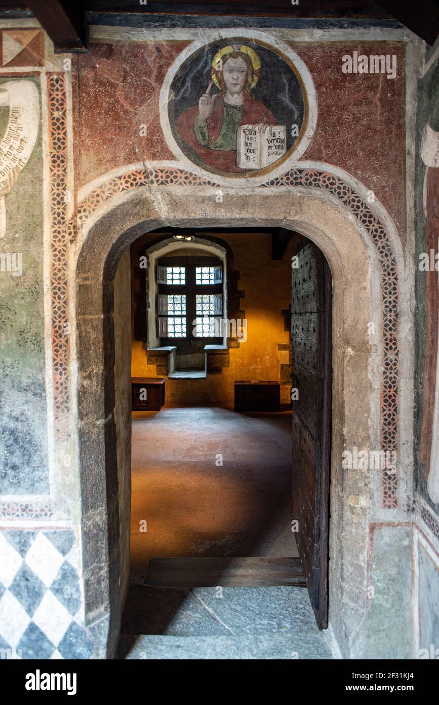 A frescoed door in Fenis Castle, Valle d'Aosta, Italy. Saint with sacred bible in a circle painting above the door Stock Photo