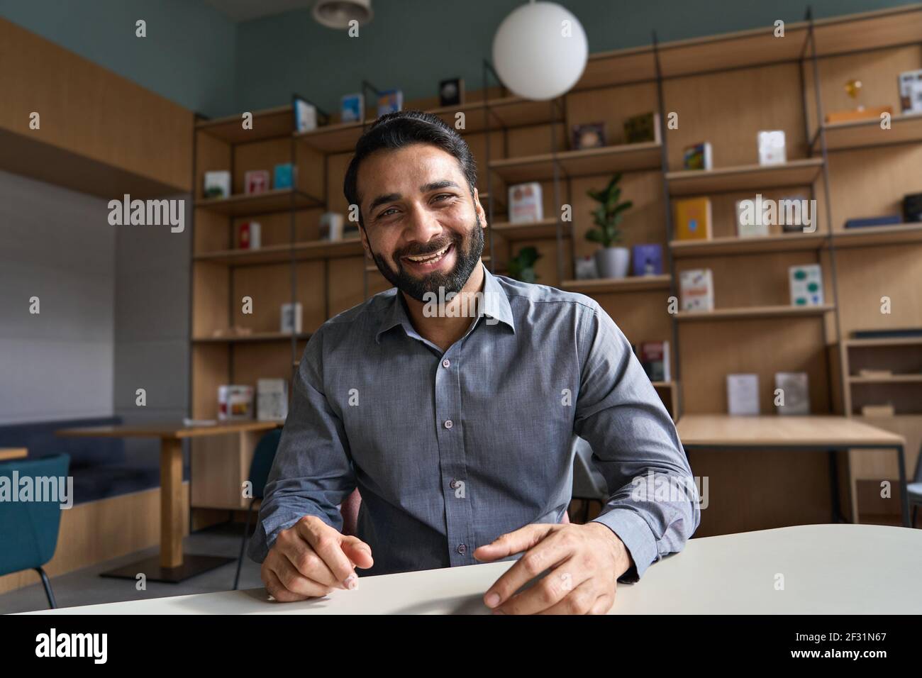 Happy indian business man, teacher talking to web cam on conference video call. Stock Photo