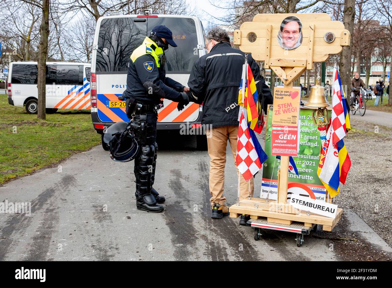 THE HAGUE, NETHERLANDS - MARCH 14: A protesters is checked by riot police during a protest on the Malieveld against the coronavirus policies and the government on March 14, 2021 in The Hague, Netherlands. The protest comes days ahead of the March 17 general elections. Only 200 people were allowed by local authorities to attend the protest, but instead several thousands showed up. (Photo by Niels Wenstedt/BSR Agency/Alamy Live News) Stock Photo
