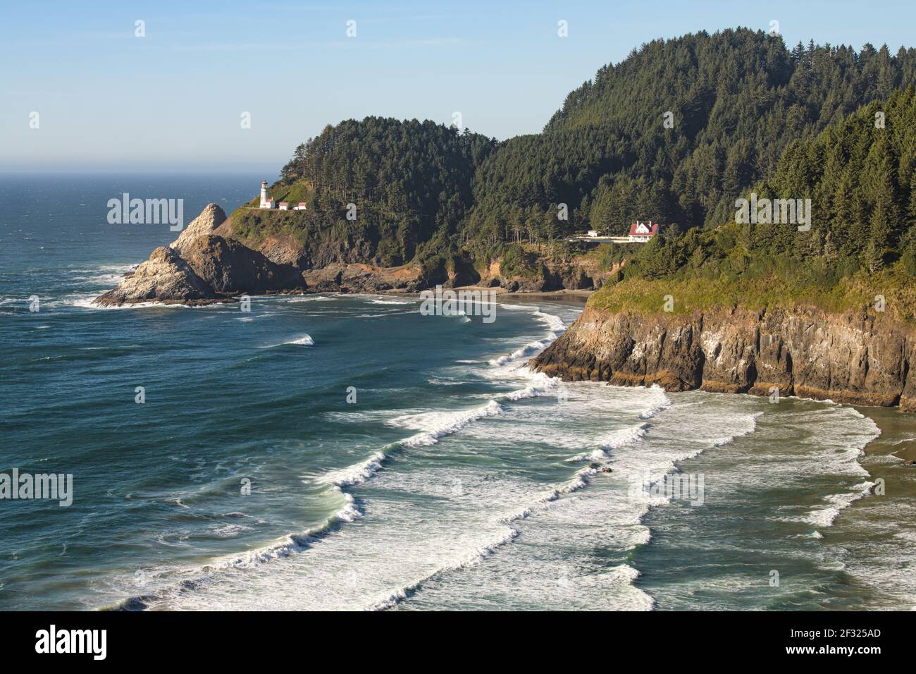 Heceta Head Lighthouse on the Central Oregon Coast and Devils Elbow cliff in the foreground with waves from the Pacific Ocean Stock Photo