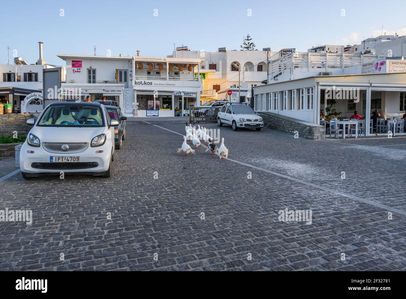 Paros, Greece - September 27, 2020: A gaggle of white geese on the street in Naoussa on Paros island, Greece Stock Photo