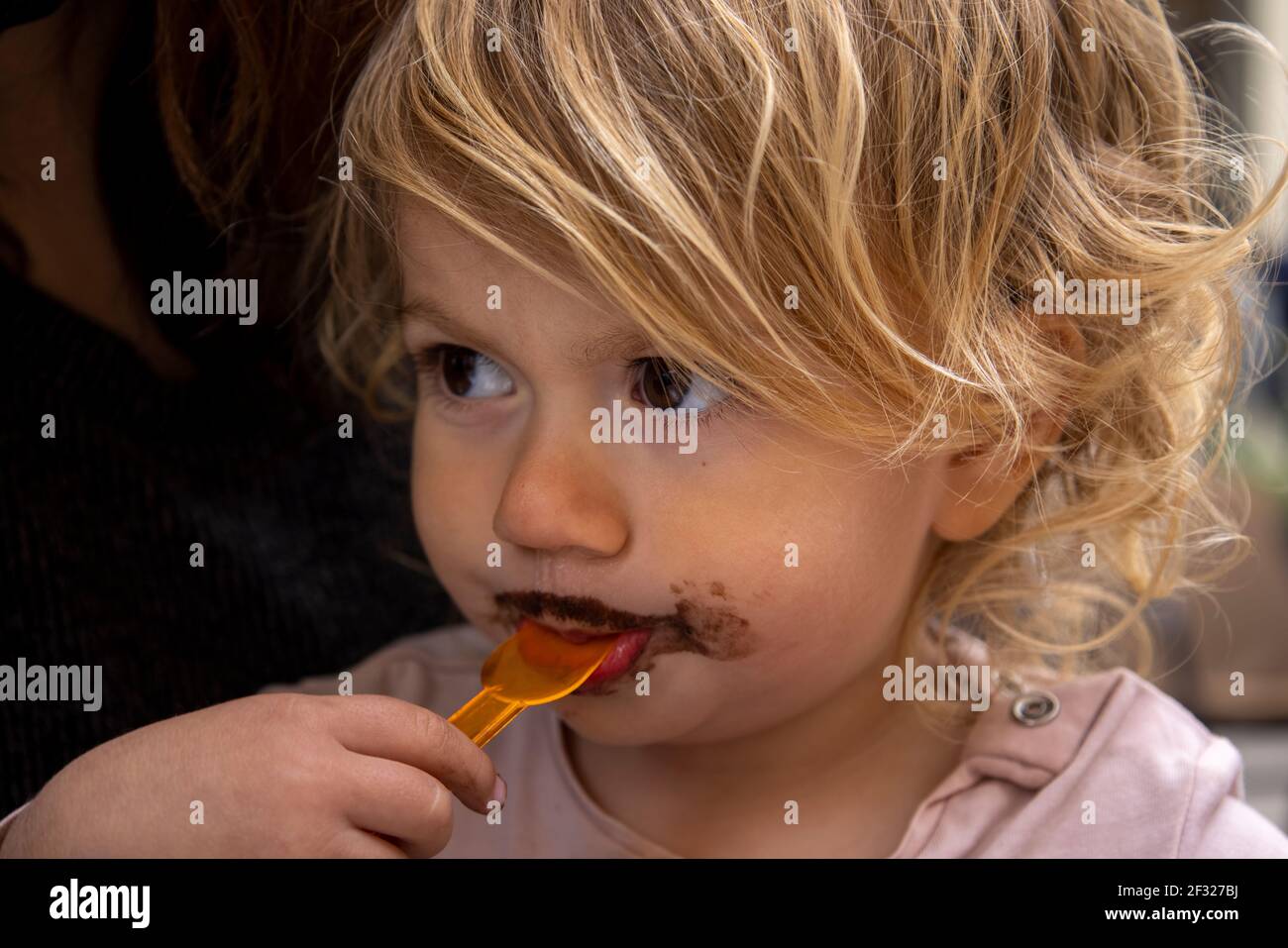 Baby girl eating chocolate icecream Stock Photo