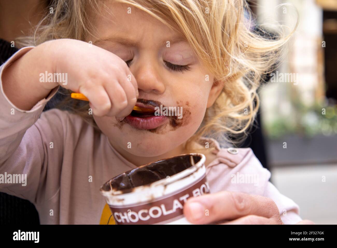 Baby girl eating chocolate icecream Stock Photo