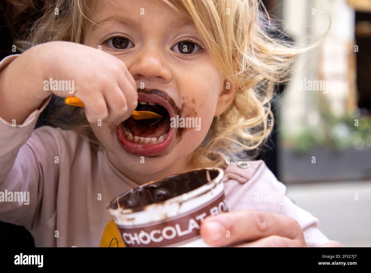 Baby girl eating chocolate icecream Stock Photo