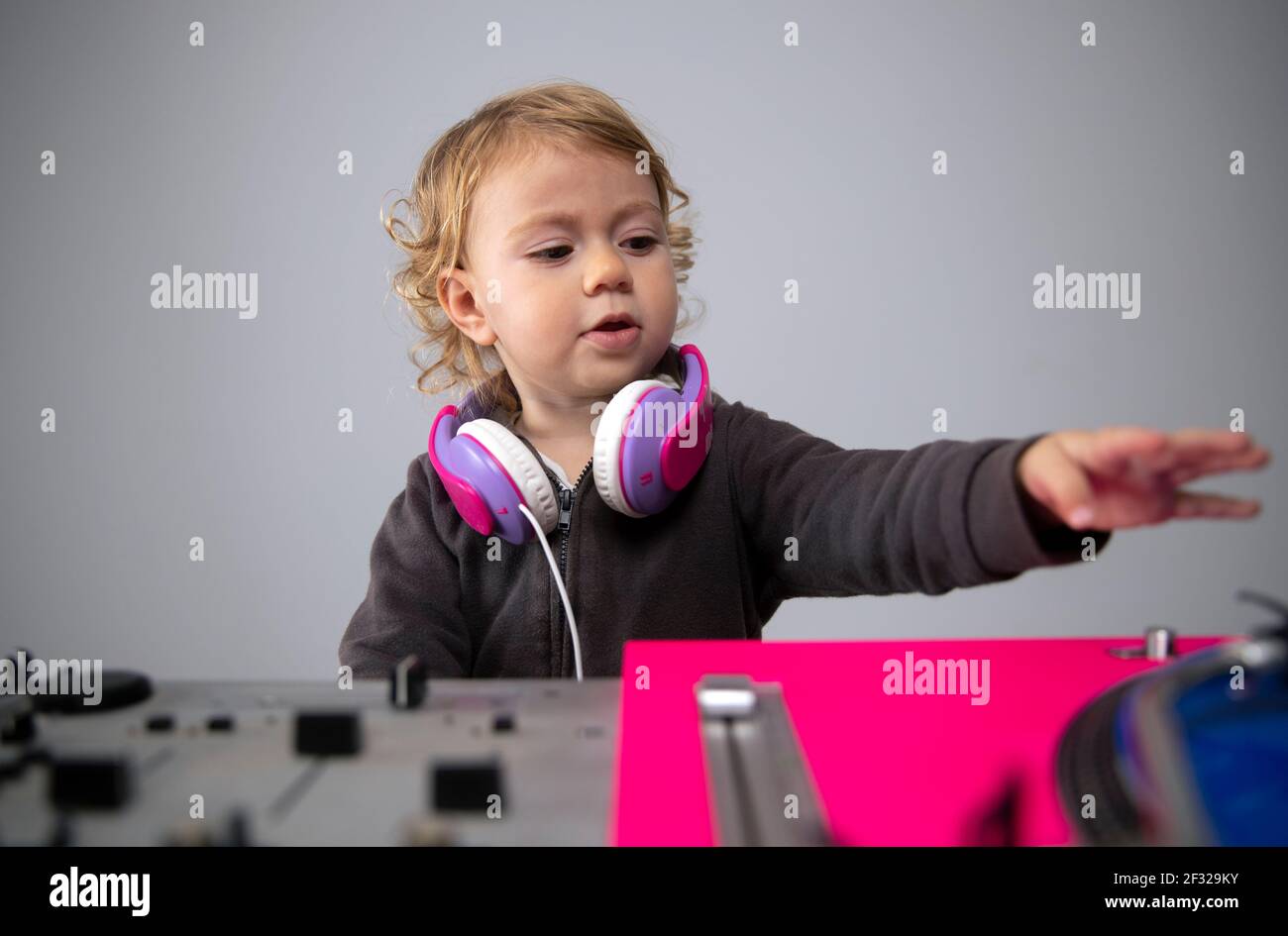 Baby girl wearing headphones with record player Stock Photo Alamy