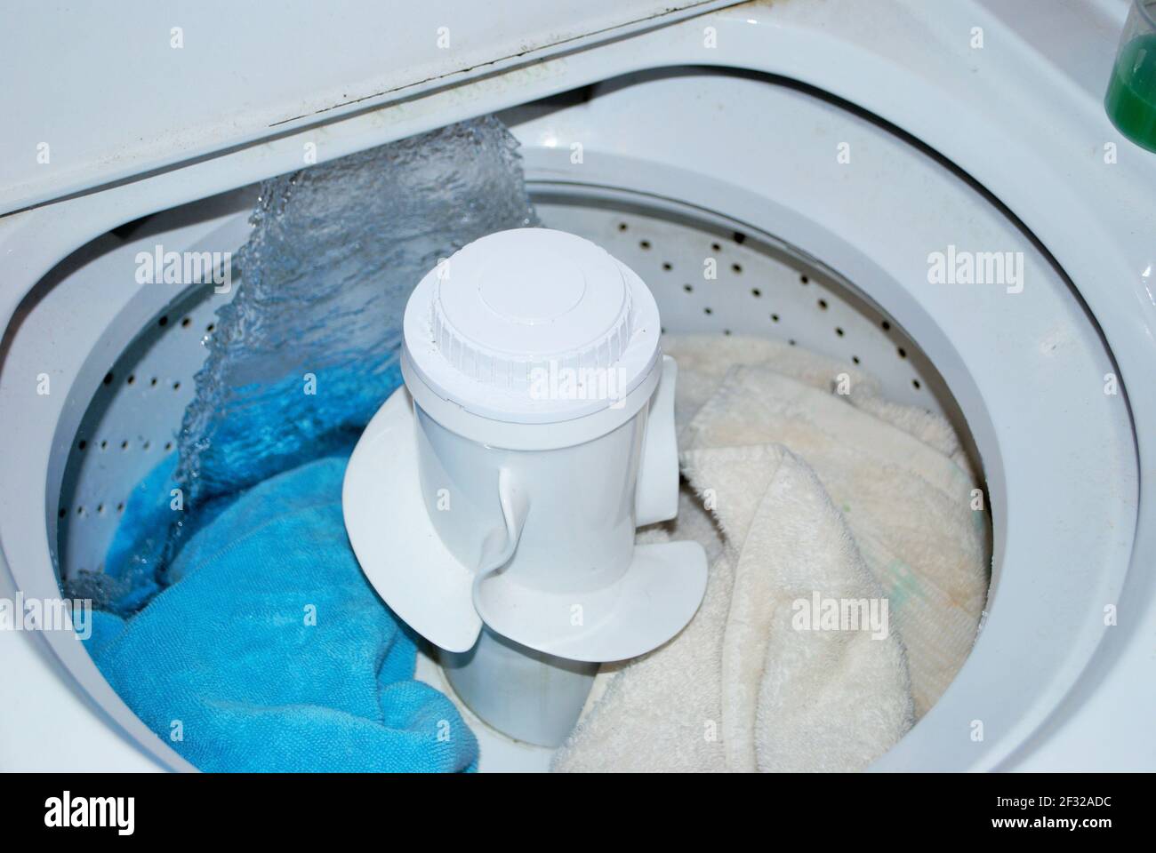 load of dirty towels in a washing machine filling with water Stock