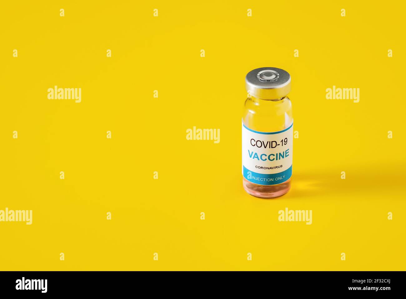 Covid-19 vaccine in glass vial on yellow background Stock Photo - Alamy