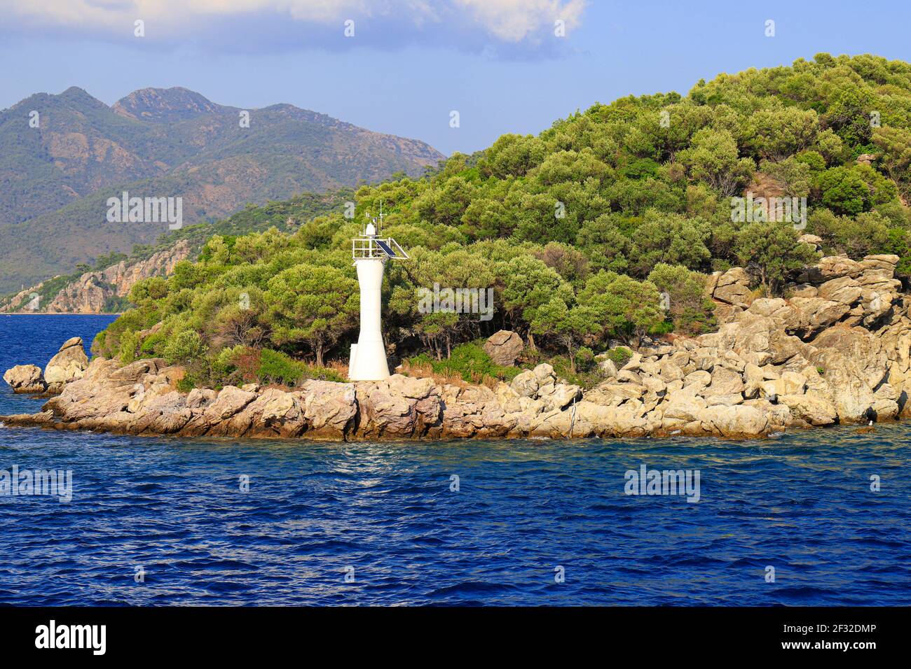 Lighthouse on a stone road in the middle of calm sea with views of ...