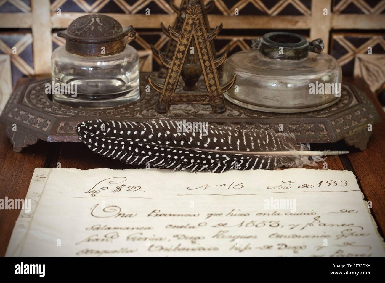 Very old inkwell and quill pen next to original 16th century manuscript