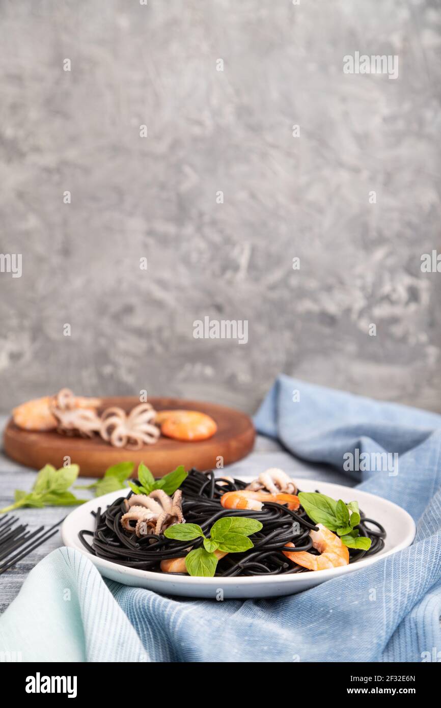 Black cuttlefish ink pasta with shrimps or prawns and small octopuses ...