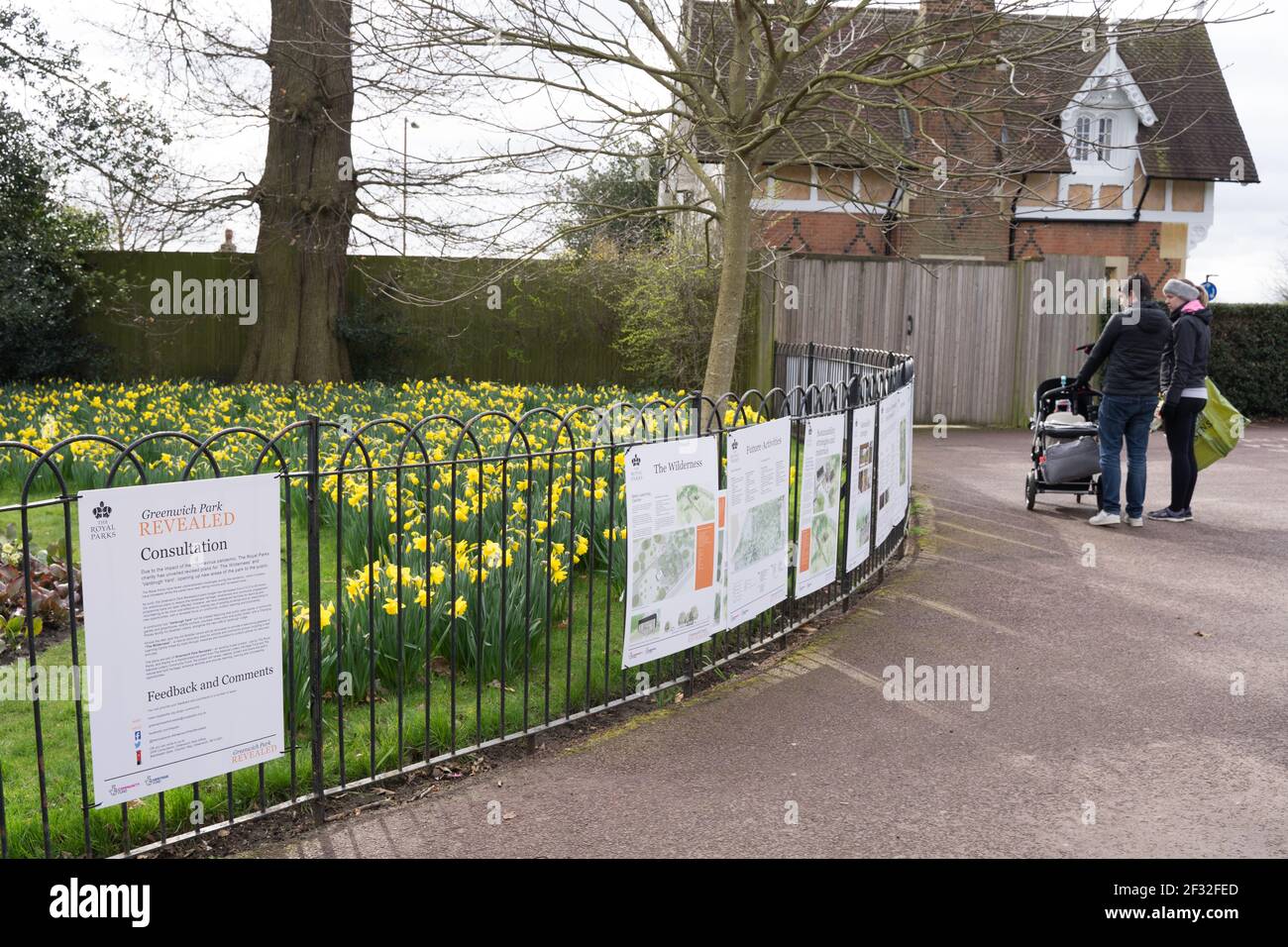 man and woman inspects the consultation papers posted on railings at greenwich Park, London, UK Stock Photo