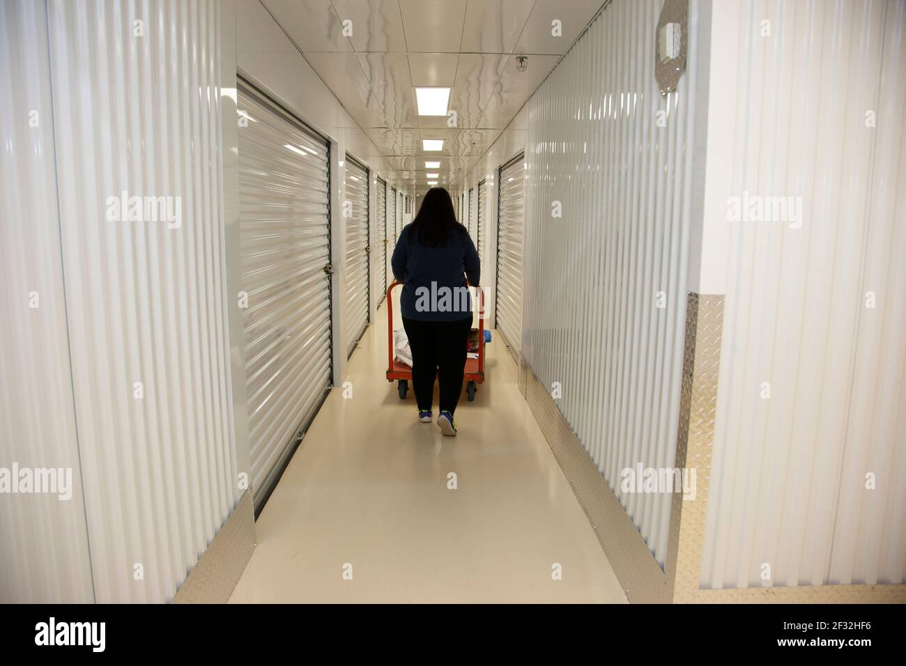 Person going to their metal self storate locker inside a storage unit Stock Photo