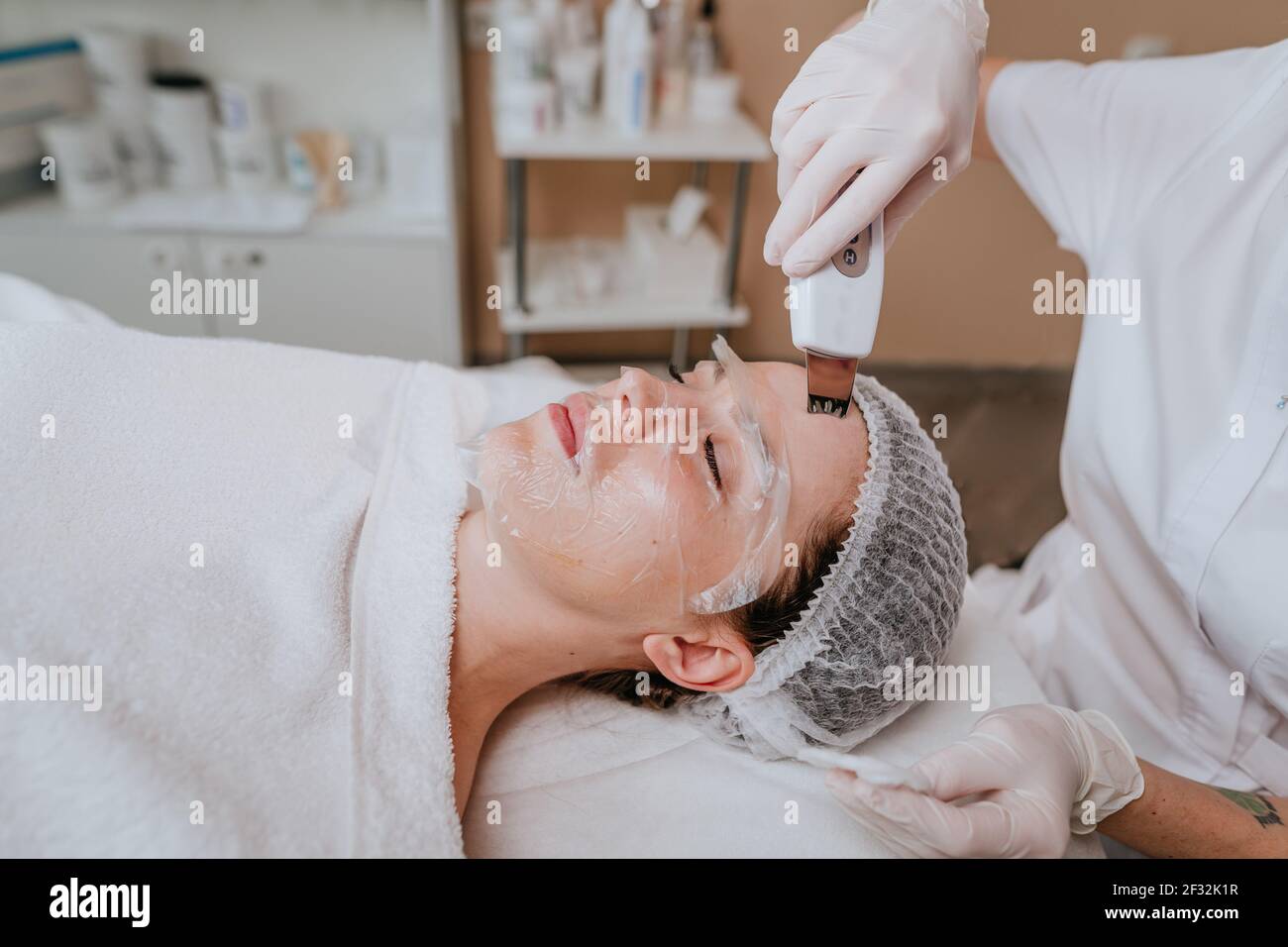 Esthetician making facial cleansing procedure using ultrasonic scin