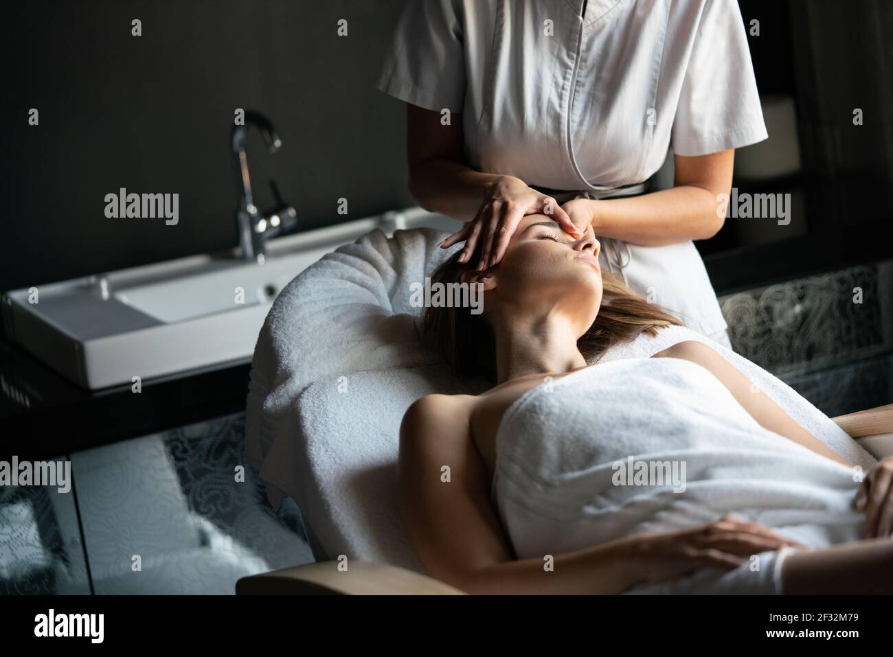 Masseur doing massage on woman body in the spa salon Stock Photo