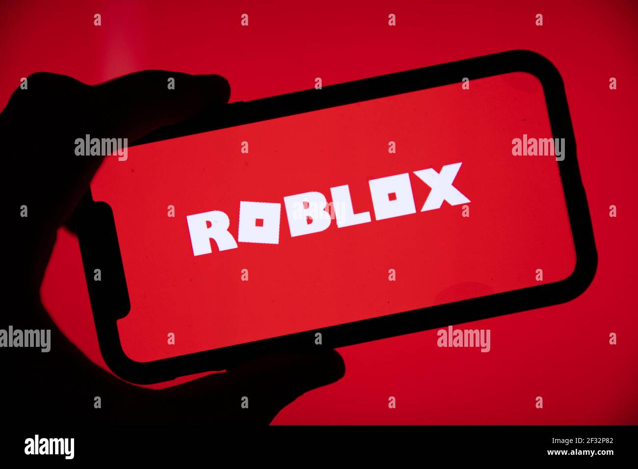 London Uk March 2021 Person Holding A Smartphone With Roblox Game Logo Stock Photo Alamy - how large is a roblox game logo