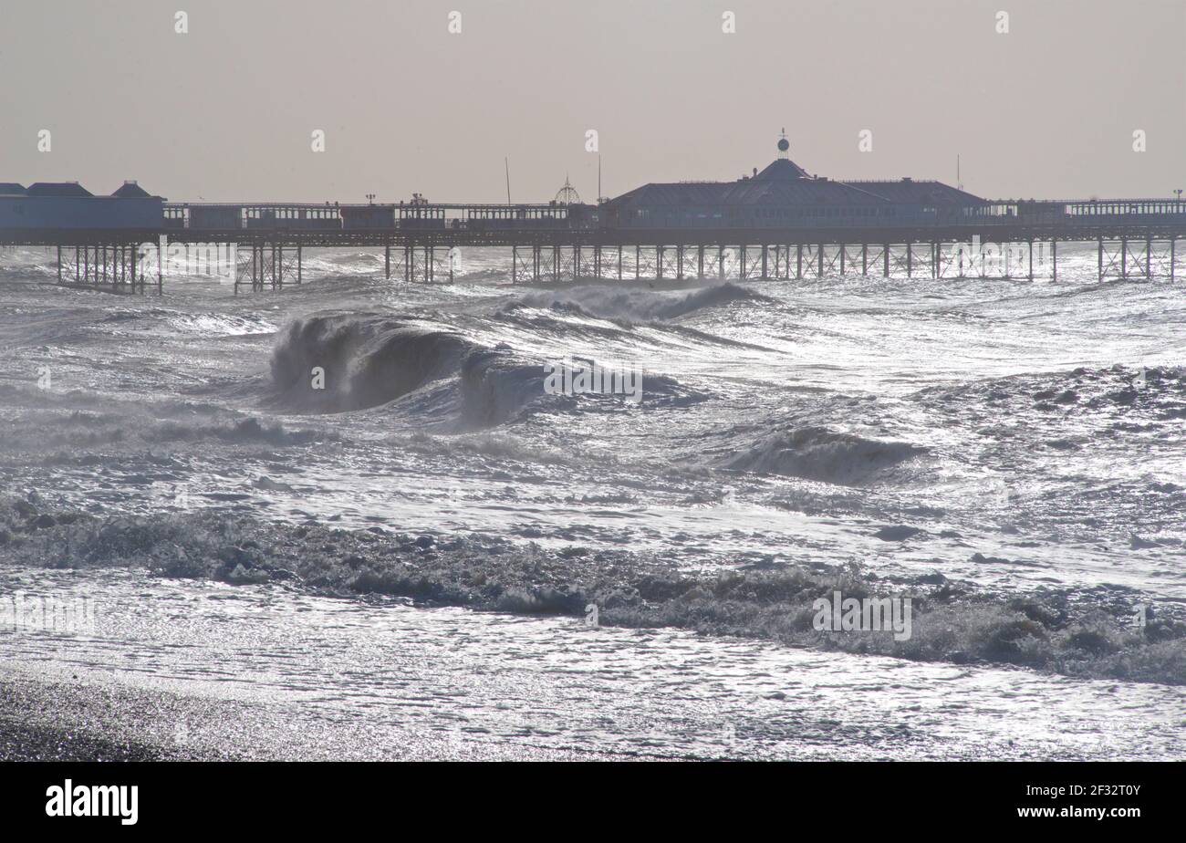 Looking east towards the Palace Pier, Brighton. Silhouette shapes and waves. Brighton beach on a stormy morning. East Sussex, England, UK. Stock Photo